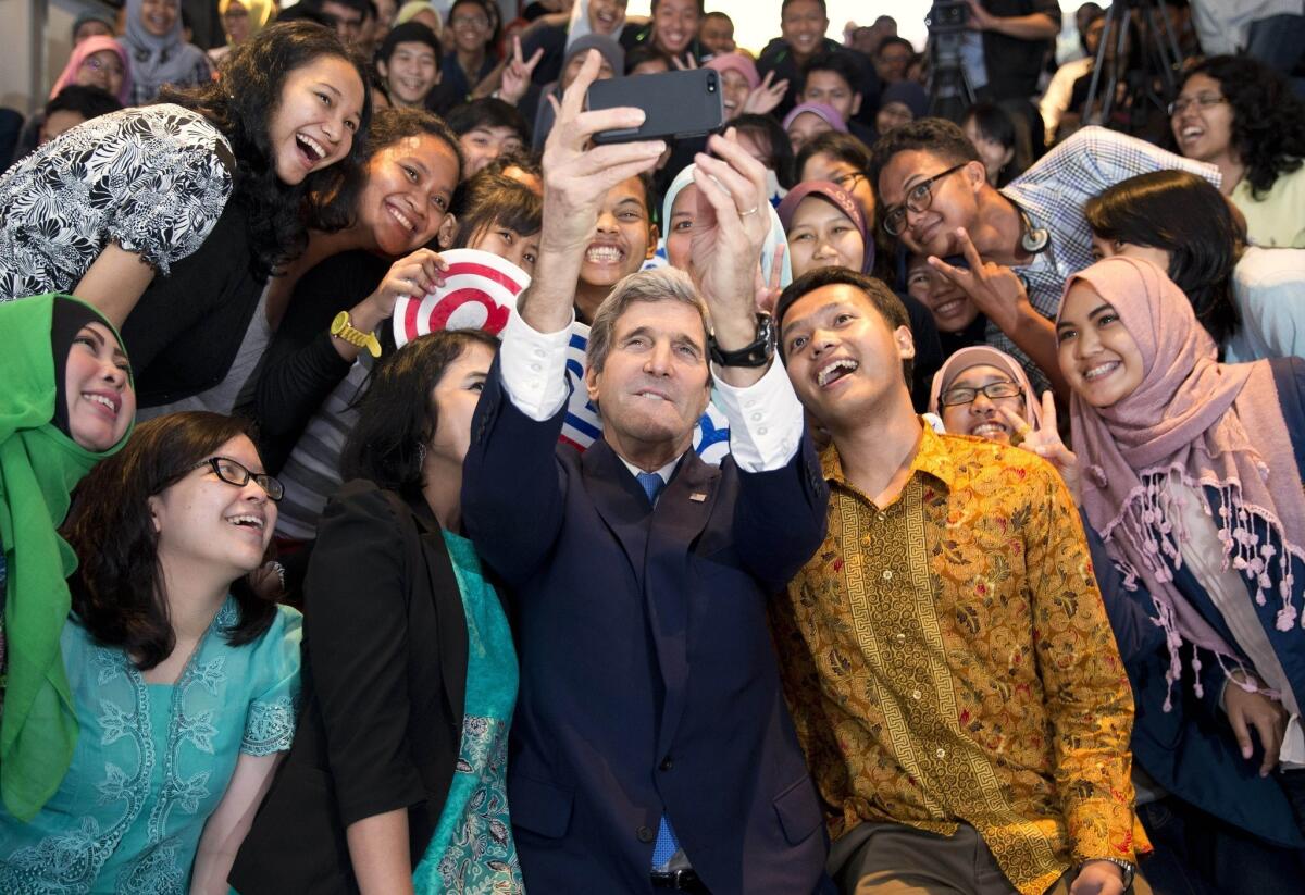 Secretary of State John F. Kerry takes a "selfie" with students before his speech on climate change in Jakarta, Indonesia.