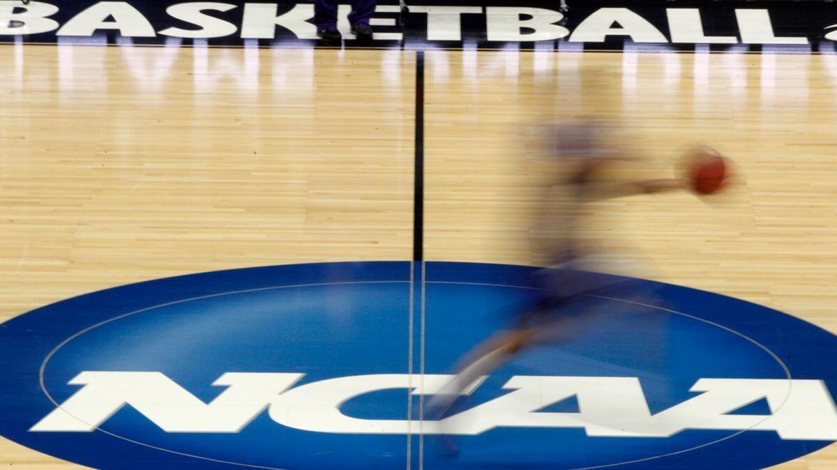 A player runs across the NCAA logo during practice in Pittsburgh before an NCAA tournament college basketball game on March 14, 2012.
