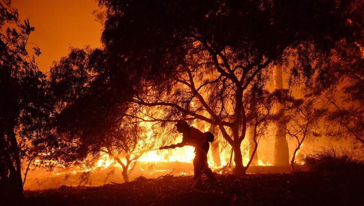 En esta imagen proporcionada por el departamento de bomberos de Santa Barbara, un bombero lucha contra las llamas cerca de un rancho en la zona del cañón de Las Flores, al oeste de Goleta, California, en las primeras horas del jueves 16 de junio de 2016.