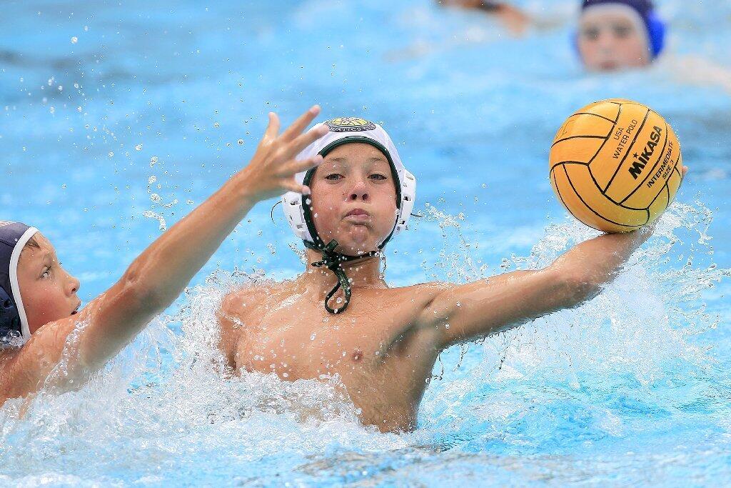Costa Mesa Aquatics Club's Caedmon Fisher, right, scores a goal against Los Angeles Water Polo Club's Thomas Beres, left, during a USA Junior Olympics semifinal match at Mater Dei High in Santa Ana on Tuesday.