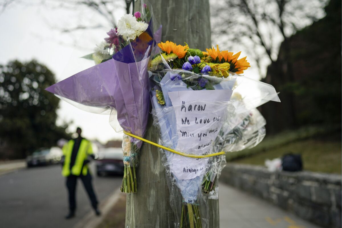 FILE - Flowers are secured to a pole as a memorial to Karon Blake, 13, on the corner of Quincy Street NE and Michigan Avenue NE in the Brookland neighborhood of Washington, Jan. 10, 2023. The note reads, "Karon we will love and miss you dearly." Jason Lewis, a longtime Parks and Recreation Department employee, turned himself in Tuesday morning to face charges of second-degree murder while armed. Lewis shot middle schooler Karon Blake on Jan. 7, around 4 a.m. (AP Photo/Carolyn Kaster, File)