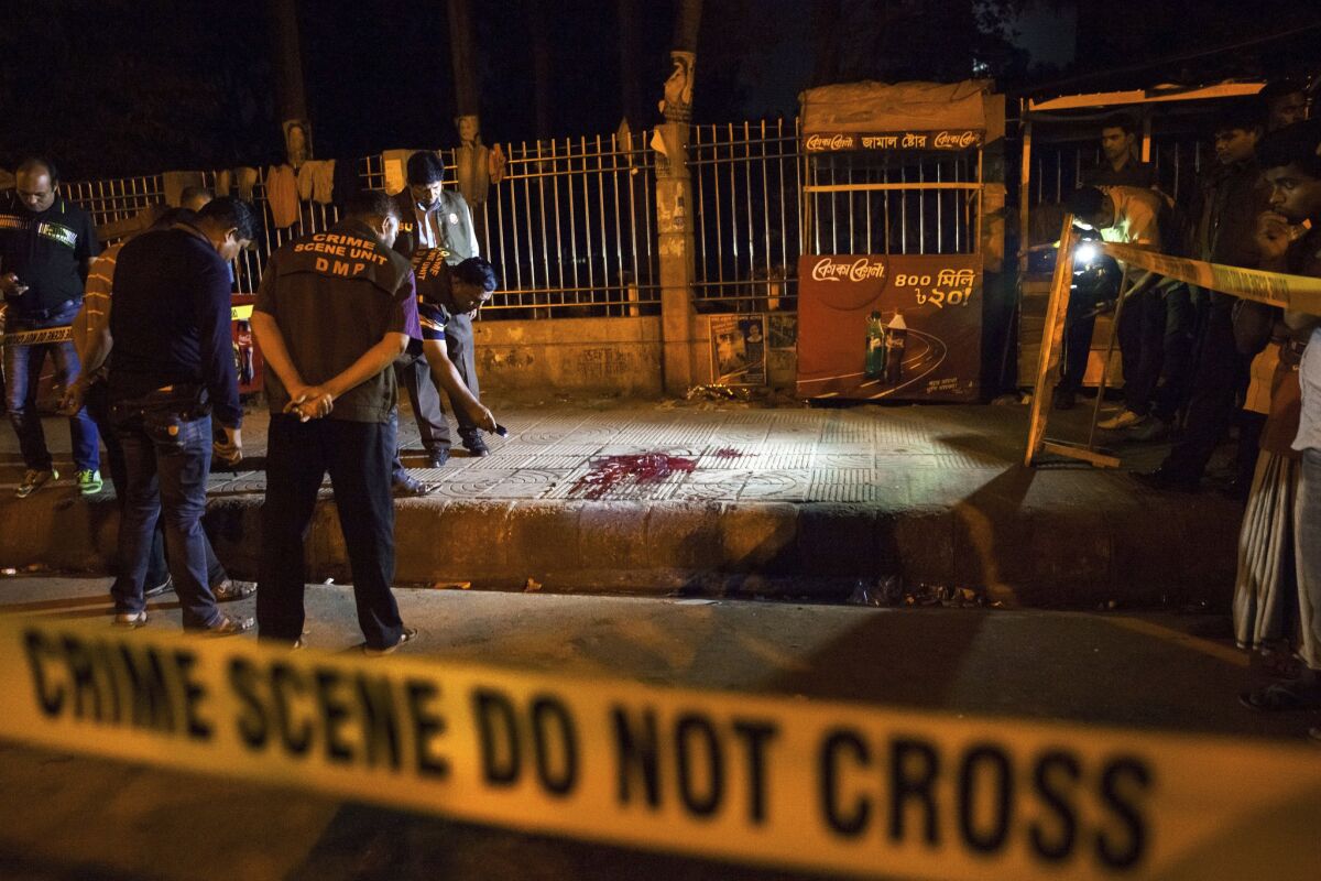 In this February 2015 photo, police investigate the scene of the attack on blogger Avijit Roy in Dhaka, Bangladesh.