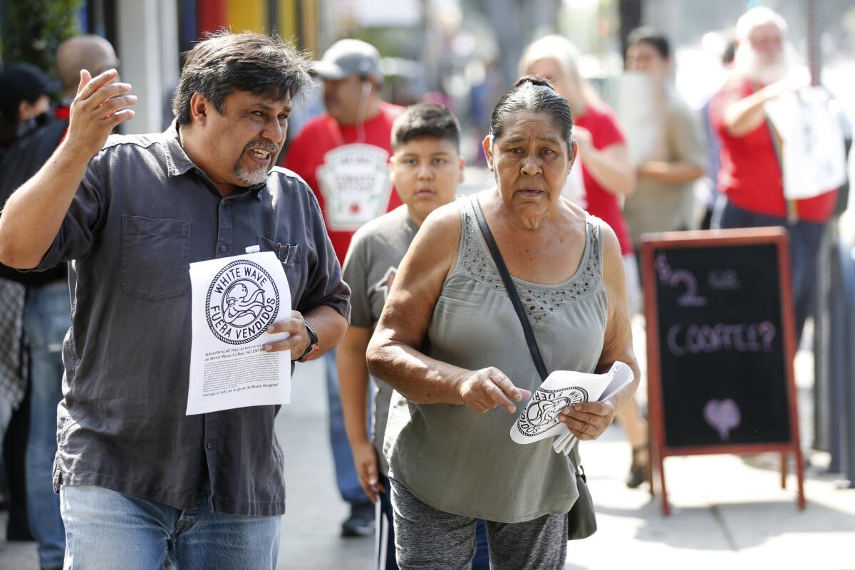 Leonardo Vilchis Sr., left, hands out fliers to the community boycotting Weird Wave Coffee in Boyle Heights.