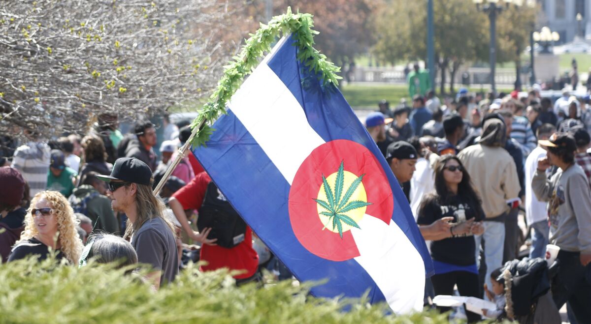A man carries a modified version of the state flag of Colorado during activities on the unofficial marijuana holiday on April 20 in Denver.