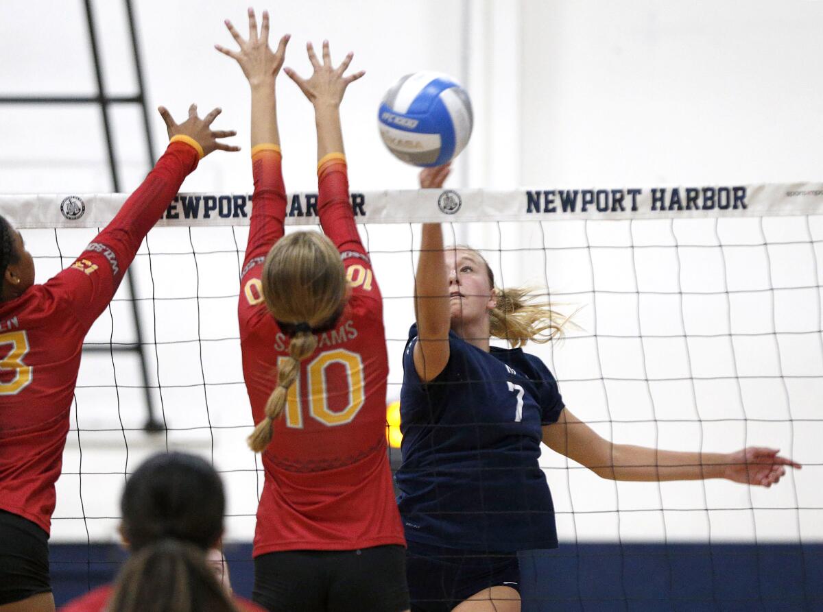 Newport Harbor outside hitter Ella Olson (7) tips a ball past Long Beach Wilson blocker Simrin Adams (10) on Wednesday.