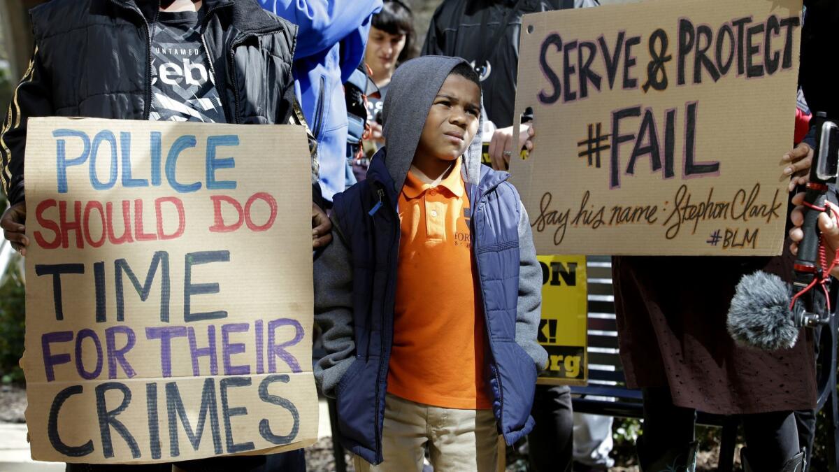 A boy joins others at a demonstration outside Sacramento City Hall in March 2018 to protest the shooting of Stephon Clark by a pair of Sacramento police officers.