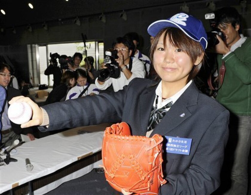 Japanese high school student Eri Yoshida, 16, smiles as she poses for photographers after being drafted by an independent league's professional team during a press conference in Osaka, western Japan, Sunday, Nov. 16, 2008. Yoshida, who throws a side-arm knuckleball, was drafted by the Kobe 9 Cruise in a new independent Japanese league that will start its first season in April. Yoshida says she wants to follow in the footsteps of Boston Red Sox knuckleballer Tim Wakefield. (AP Photo/Kyodo News)