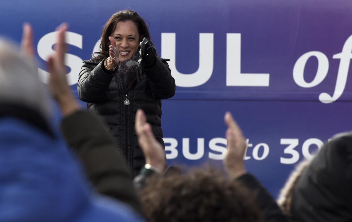 Kamala Harris gestures to applauding supporters at a campaign stop.