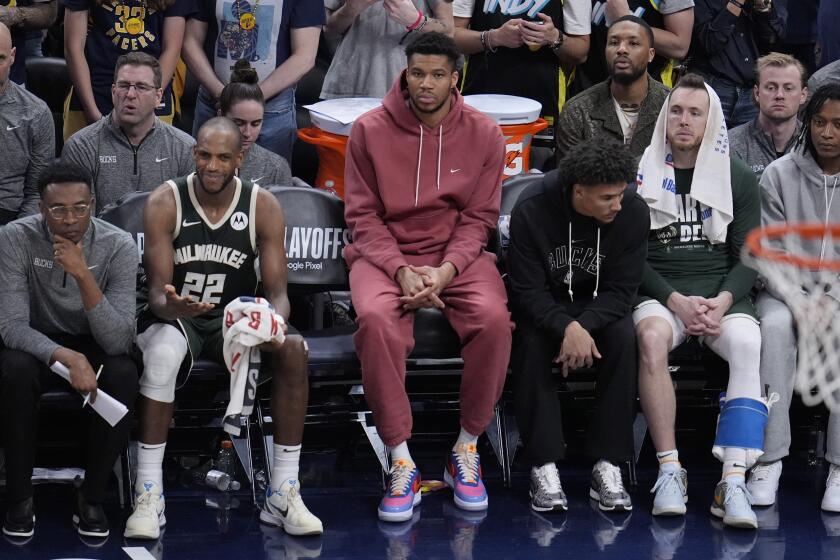 Milwaukee Bucks' Giannis Antetokounmpo, middle, watches along with teammates during the second half of Game 4 of the first round NBA playoff basketball series against the Indiana Pacers, Sunday, April 28, 2024, in Indianapolis. (AP Photo/Michael Conroy)
