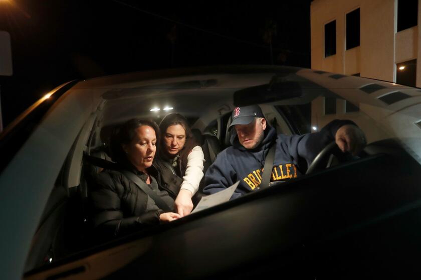 SAN PEDRO, CALIF. - JAN. 25, 2018. Kathy Creighton, left, and her husband, Ken Creighton, are joined by Kamara Shephard as they figure out directions on a map of San Pedro while performing a count of homeless people from their car on Wednesday night, Jan. 25, 2018. (Luis Sinco/Los Angeles Times)