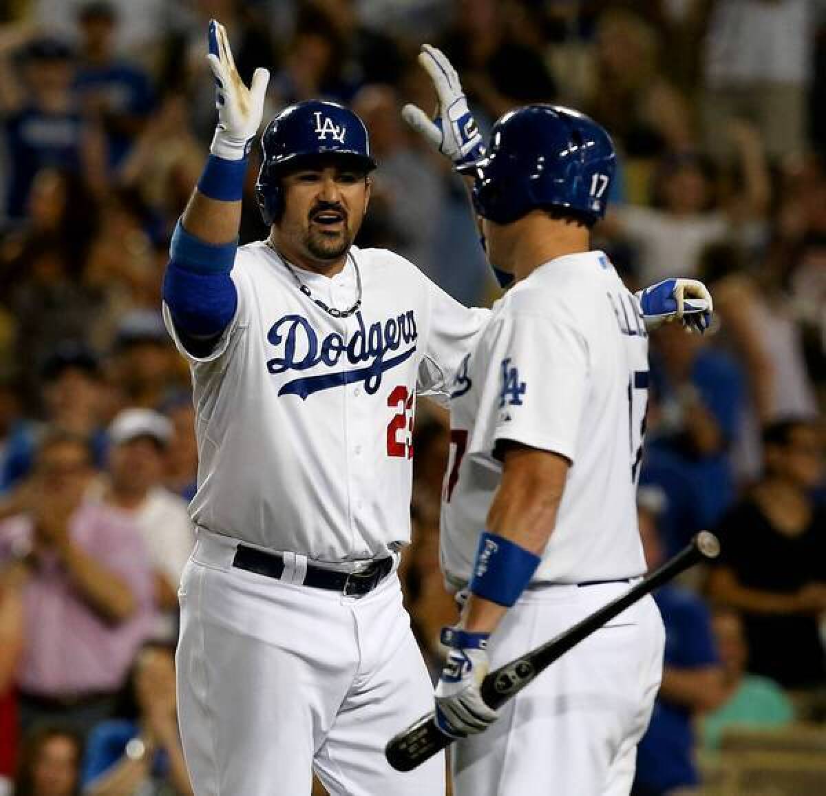 Dodgers teammates Adrian Gonzalez and A.J. Ellis give each other a high five. The team's new owners have been spending big on talent and are seeing results. [For the Record, 12:06 p.m. PDT Oct. 6: An earlier version of this caption misidentified A.J. Ellis as Mark Ellis.]