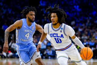 UCLA point guard Tyger Campbell drives against North Carolina's RJ Davis during a Sweet 16 game March 25, 2022.