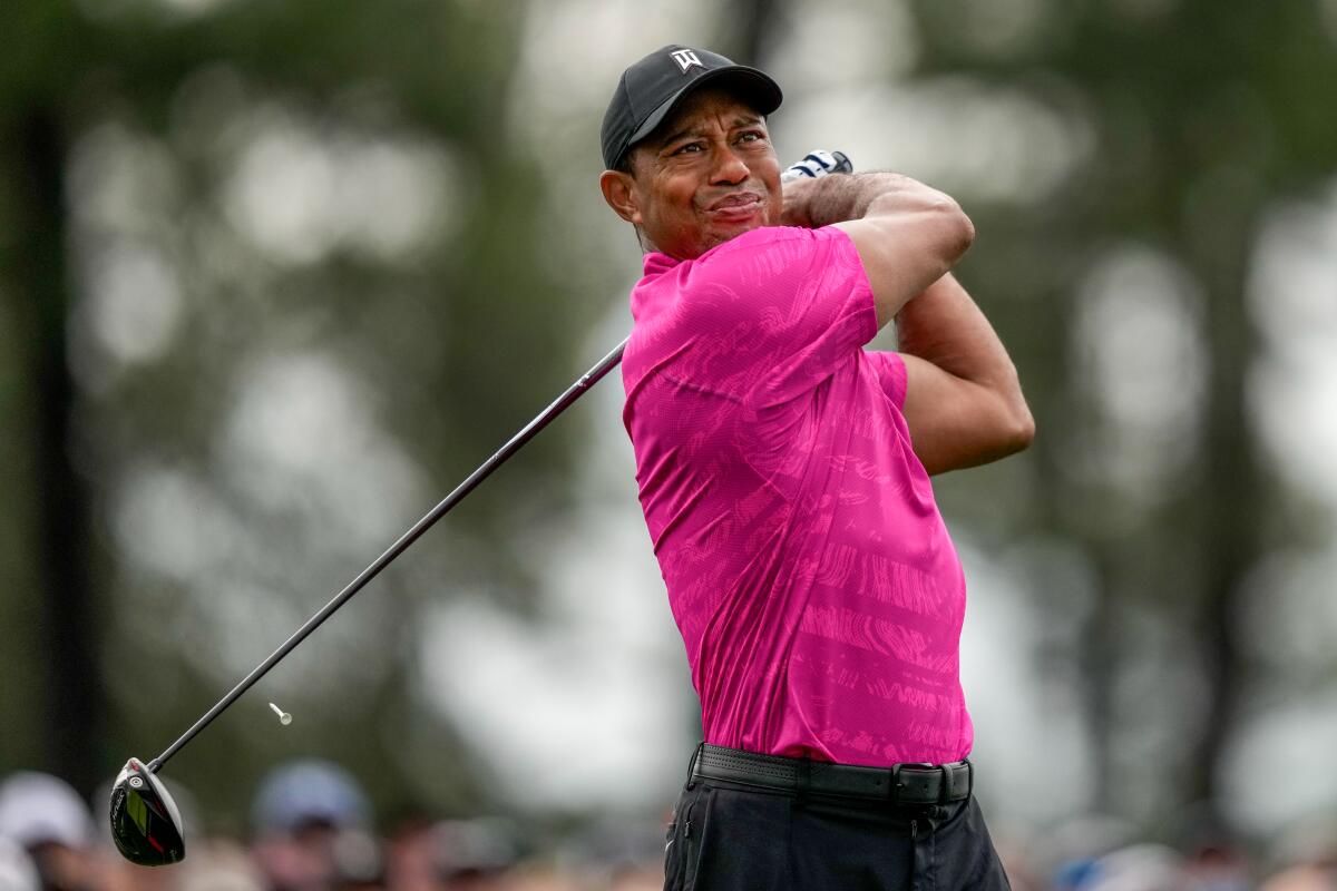 Tiger Woods watches his tee shot on the first hole during the first round of the Masters golf tournament.