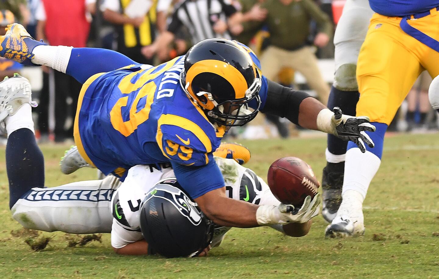 Rams' Aaron Donald falls on Seattle Seahawks quarterback Russell Wilson while trying to recover a fumble in the fourth quarter at the Coliseum on Sunday.