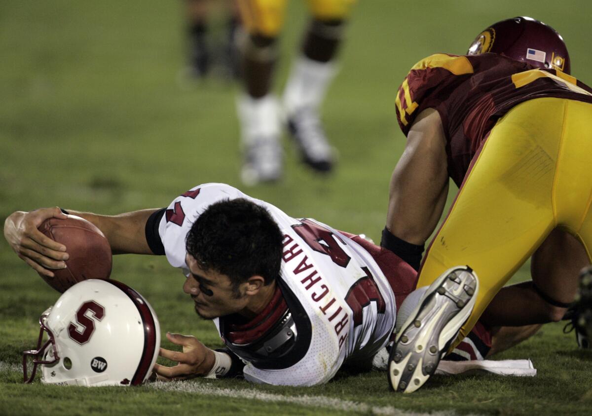 Stanford Cardinal quarterback Tavita Pritchard loses his helmet as he reaches out for a first down 