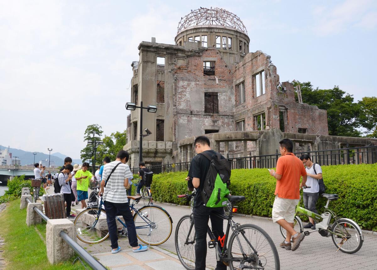 En esta imagen de archivo, tomada el 26 de julio de 2016, un grupo de personas juega a Pokémon Go cerca de la Cúpula de la Bomba Atómica, en el Peace Memorial Park de Hiroshima, Japón. (Kyodo News via AP, archivo)