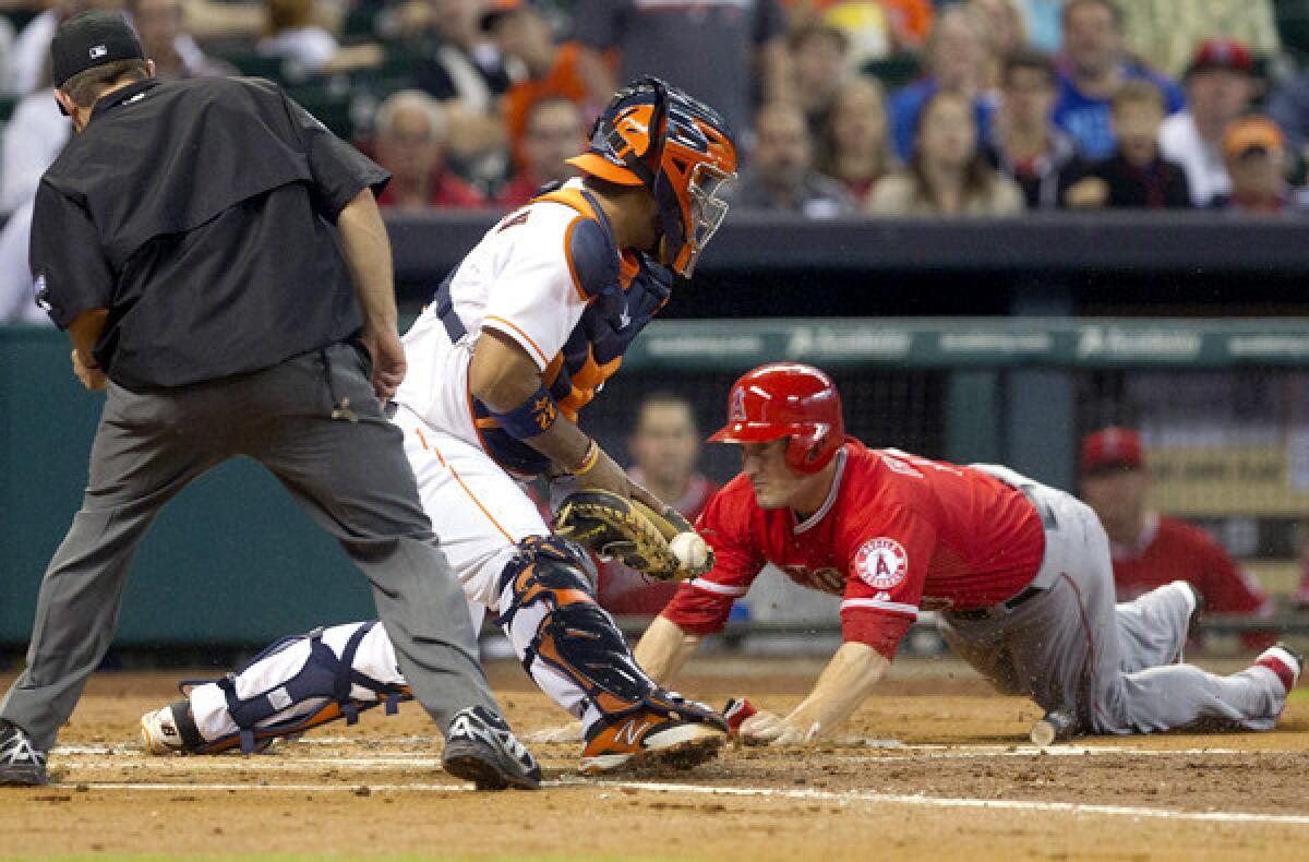 Angels third baseman David Freese dives toward home plate around Astros catcher Carlos Corporan during a play in the sixth inning Saturday night.