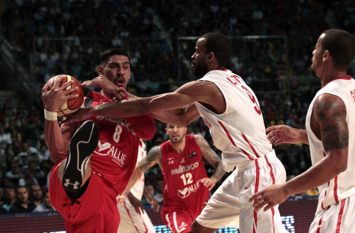 El mexicano Gustavo Ayón (i) intenta pasar la marca de Levy Jamaal (c ), de Panamá, en partido del Torneo FIBA Américas, clasificatorio para los Juegos Olímpicos de Río de Janeiro 2016, en Ciudad de México.