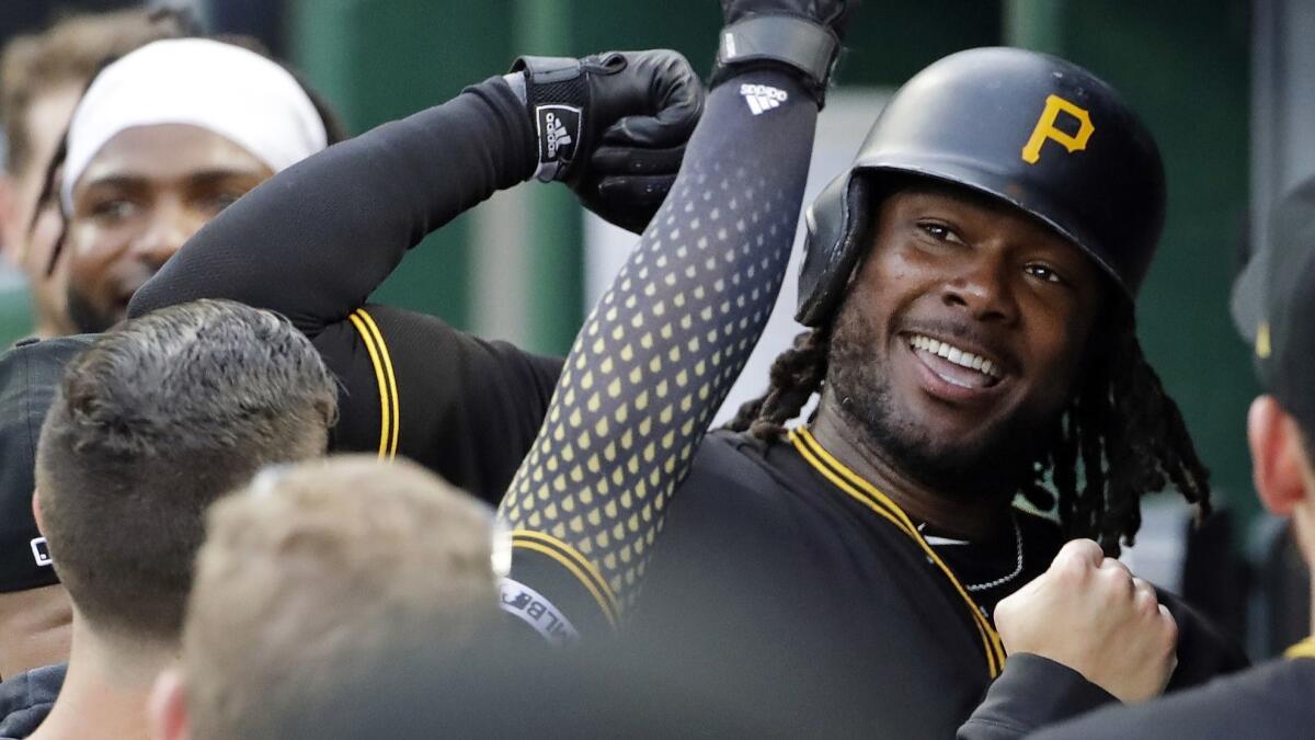 The Pittsburgh Pirates' Josh Bell, right, celebrates in the dugout after hitting a home run off Colorado Rockies pitcher Jon Gray on May 22.