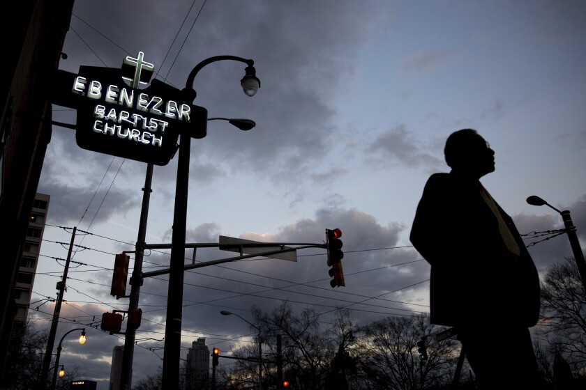 FILE - In this early Monday, Jan. 16, 2017 file photo, a man walks past the Ebenezer Baptist Church in Atlanta. The historic congregation at the heart of Atlanta, where the Rev. Martin Luther King Jr. had preached, sits at the intersection of national politics and the fate of a handful of pressing national policy fights. (AP Photo/Branden Camp)