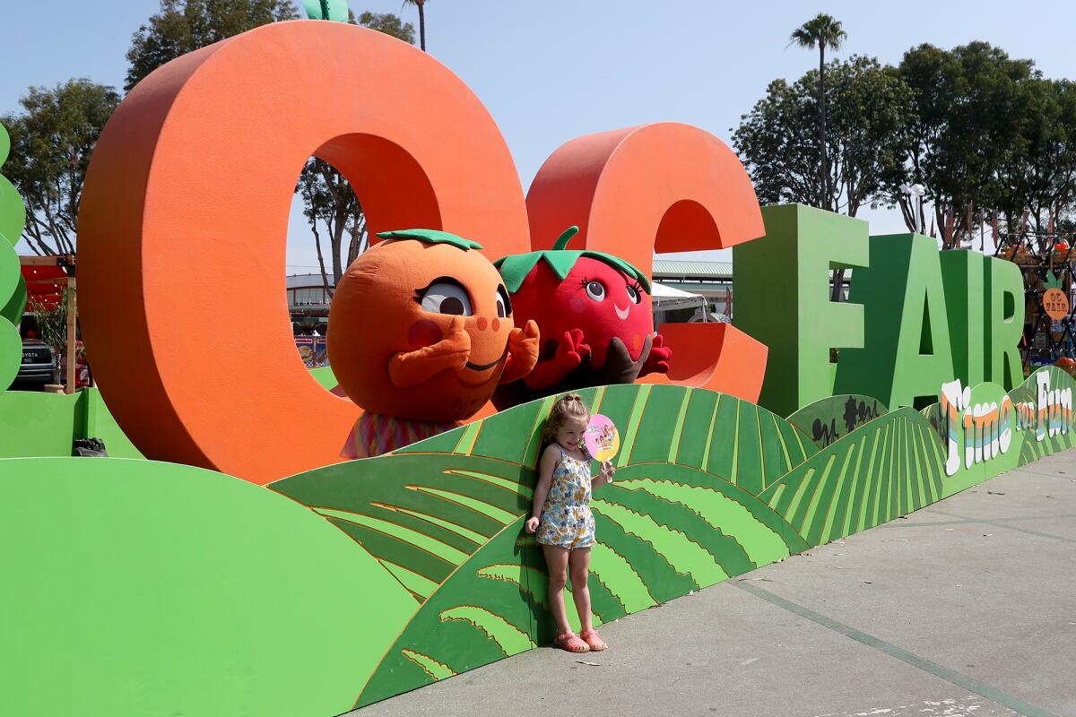 Fair foodies Olivia the Orange and Strawberry Jan pose for a photo Friday on opening day of the O.C. Fair in Costa Mesa.