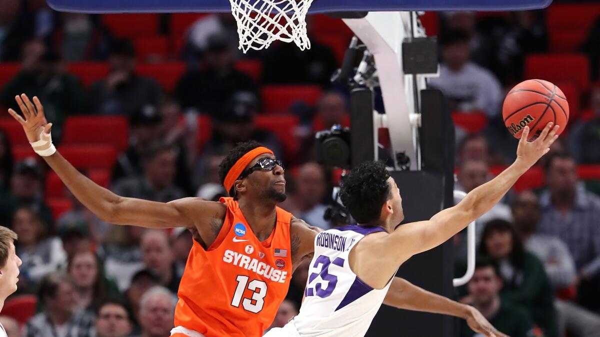 TCU's Alex Robinson is forced into an awkward shot by Syracuse's Paschal Chukwu during the first half.
