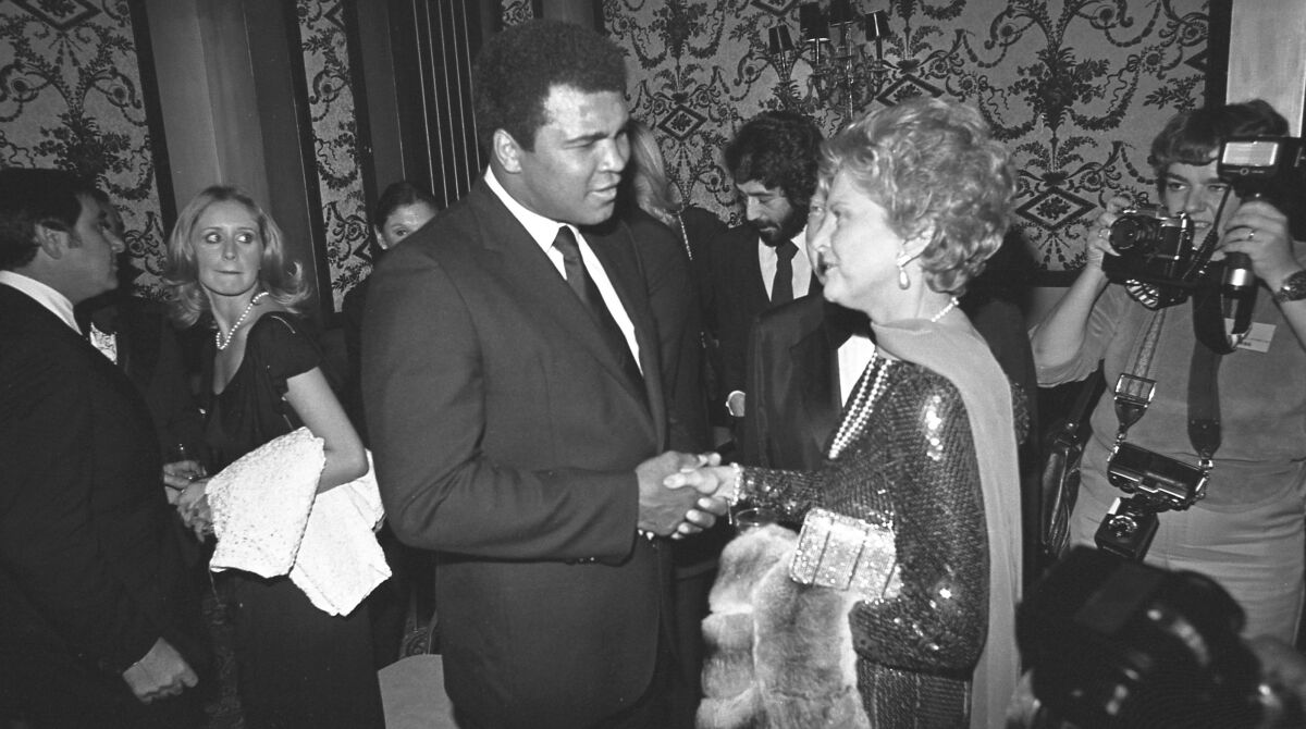 Muhammad Ali and Betty Ford shake hands.