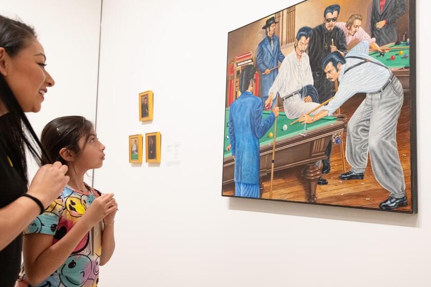 Ana Tavares (38) and her daughter Tahlia Tavares (8) examine a painting by Emigdio Vasquez on display at the Hilbert Museum of California Art in Orange on Wednesday, Feb. 28.