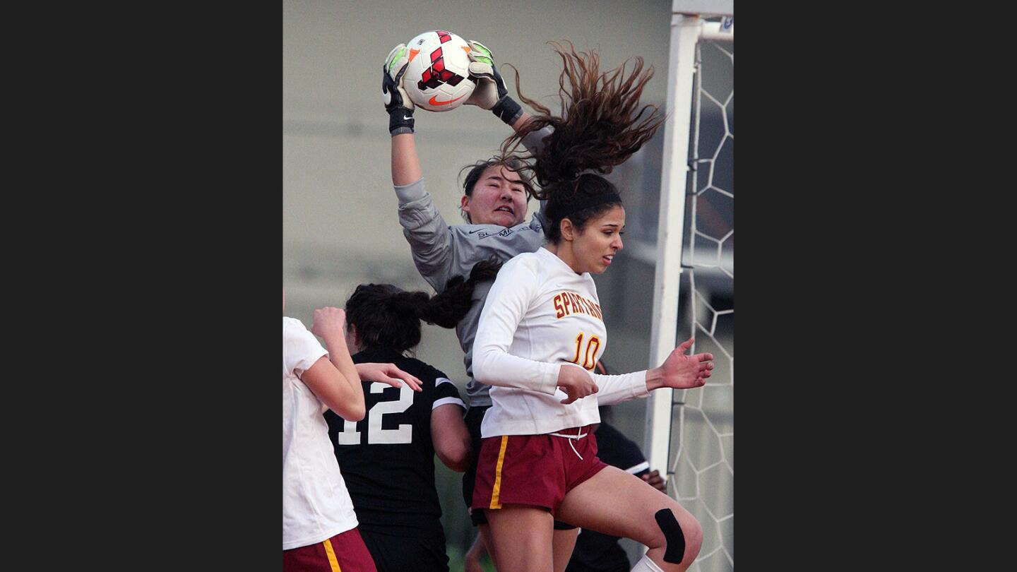 Flintridge Sacred Heart's goalie Giulia Cascapera gets ahold of the ball off of a La Cañada corner kick with La Canada's Gianna Mor trying to head the ball in a non-league girls' soccer game at La Cañada High School on Monday, January 9, 2017.