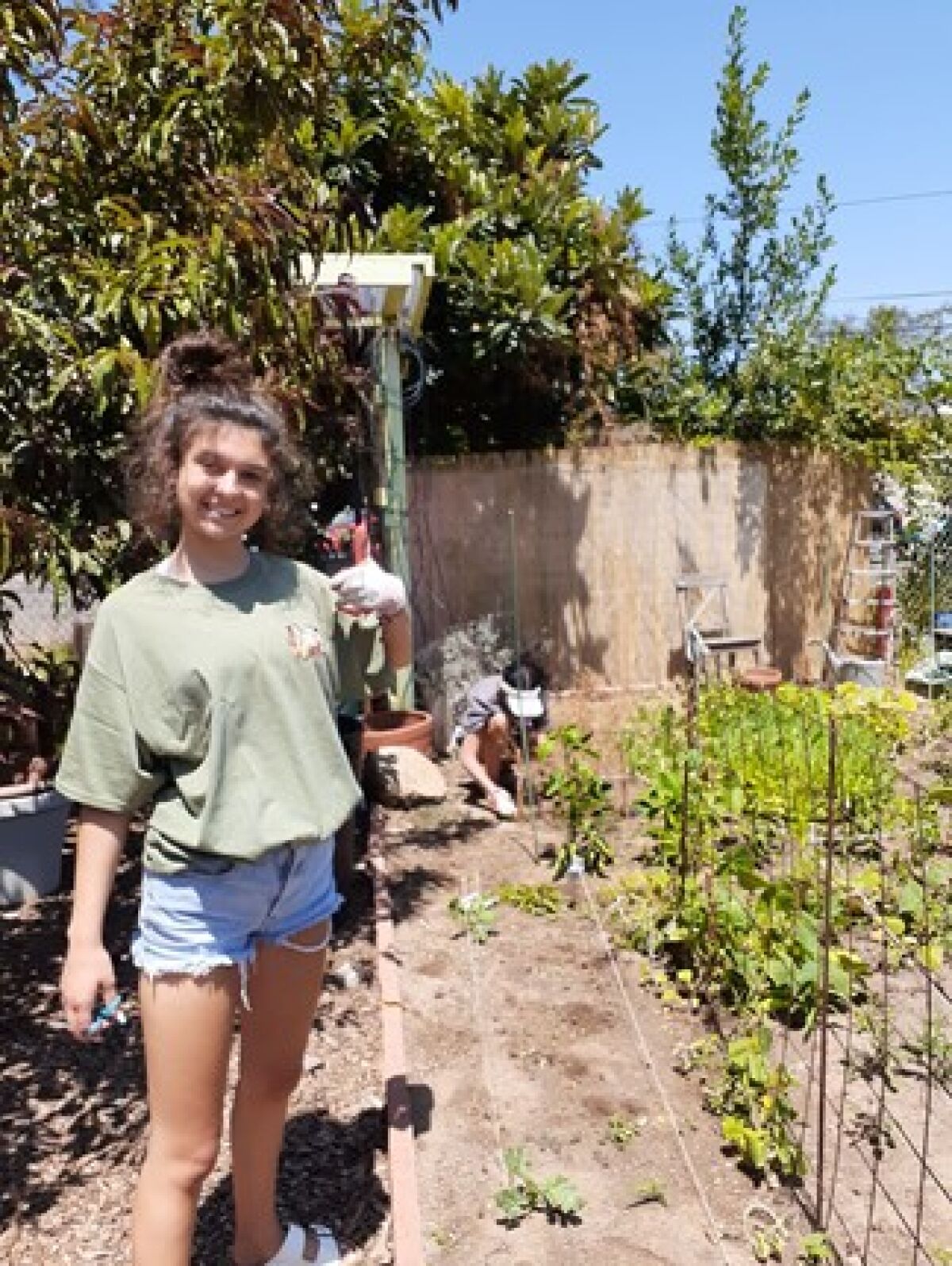 OB Community Garden Club student volunteer Teira Frerichs (foreground) joins Fania Villarreal (right) at the garden.