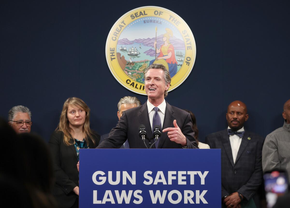 Gov. Gavin Newsom behind a lectern that says "Gun safety laws work"