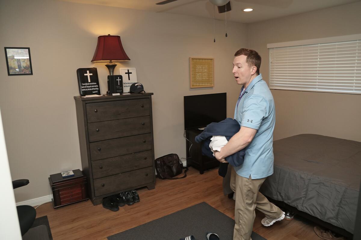 Army veteran Samuel Johnson gives a tour of his bedroom at Orange County Rescue Mission's Tustin Veterans Outpost.