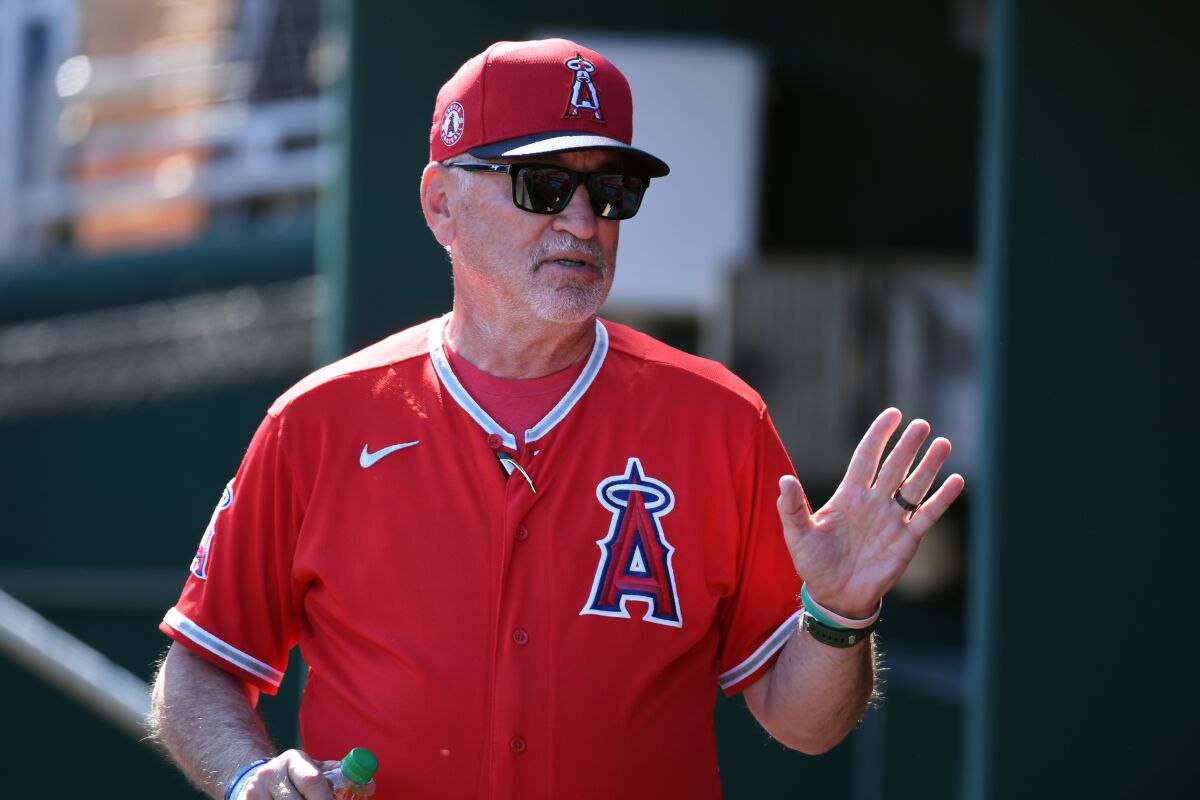 Angels manager Joe Maddon speaks with his players in the dugout prior to a spring training game against the Cleveland Indians on March 3.
