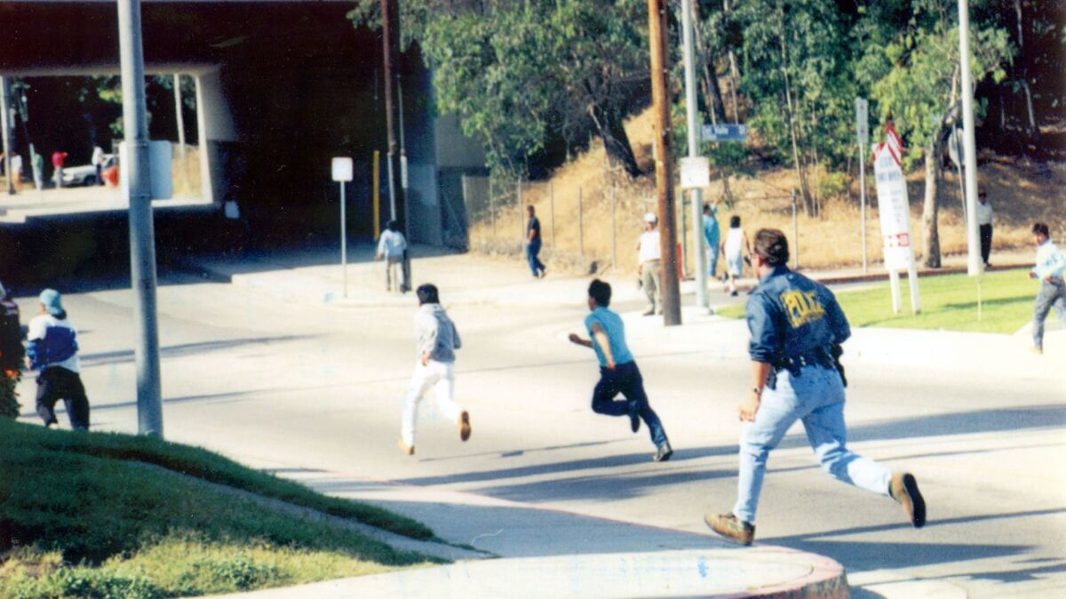 An INS officer chases suspected illegal immigrants during a 1993 raid in Los Angeles.
