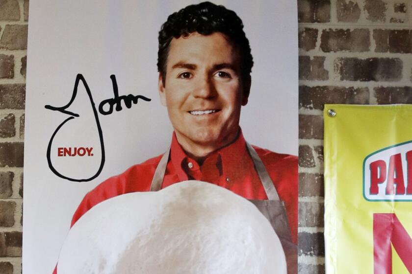 FILE- In this Dec. 21, 2017, file photo shows signs, including one featuring Papa John's founder John Schnatter, at a Papa John's pizza store in Quincy, Mass. Schnatter is no longer board chairman after using a racial slur, but his image is still part of the pizza chain's logo and he remains the company's largest shareholder. (AP Photo/Charles Krupa, File)