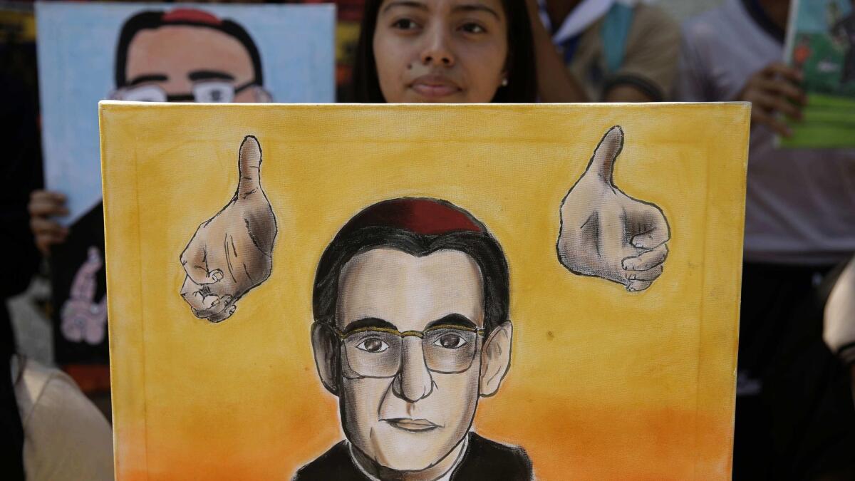 A youth holds a portrait of slain Archbishop Oscar Romero of El Salvador after the Vatican's announcement on March 7, 2018, that he will be canonized.