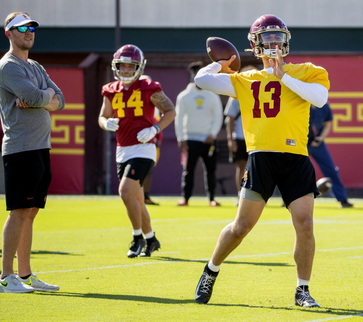 USC football coach Lincoln Riley, left, watches quarterback Caleb Williams pass during a spring practice in March.