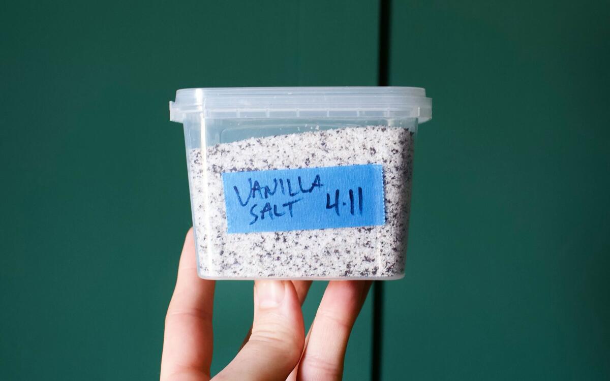 A hand holds a plastic container labeled "Vanilla Salt"