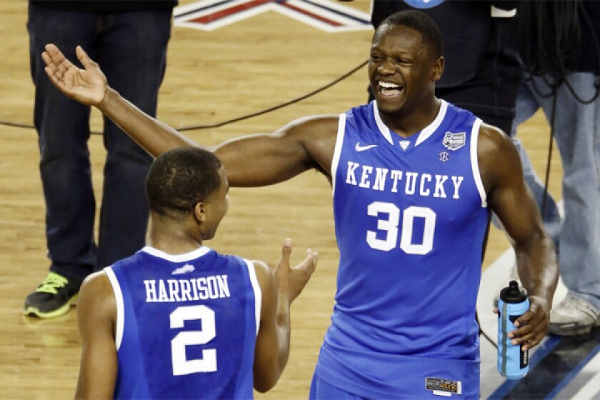 Julius Randle, right, celebrates with Kentucky teammate Aaron Harrison, whose late three-pointer lifted the Wildcats past Wisconsin and into the NCAA tournament final.