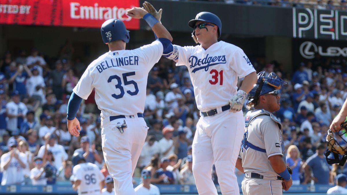 Dodgers' Joc Pederson (31) and Cody Bellinger (35) celebrate after both score on Pederson's two-run home run in the second inning against the Kansas City Royals at Dodger Stadium on Saturday.