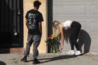 MALIBU, CA - OCTOBER 18, 2023 - Youth leave flowers at the scene where four women were killed in a multi-vehicle crash along the Pacific Coast Highway in Malibu on October 18, 2023. A 22-year-old man was arrested after plowing into the pedestrians and parked cars. The crash was reported at 8:30 p.m. Tuesday in the 21600 block of Pacific Coast Highway where they found the victims of the crash, along with the severely damaged vehicles. The crash began when the suspect lost control of his BMW and slammed into multiple parked cars before ricocheting and fatally striking the women, who were standing on the side of the road. (Genaro Molina / Los Angeles Times)