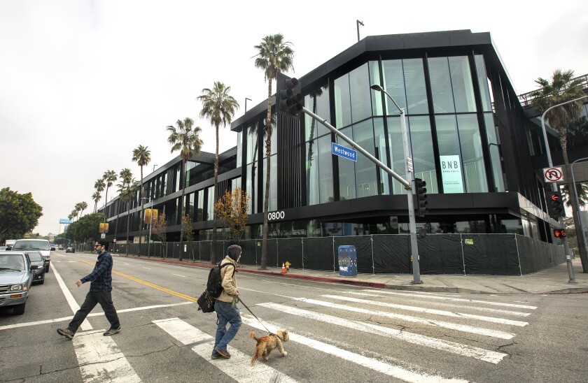 Photo shows people in a crosswalk at the One Westside complex at Westwood and Pico boulevards.