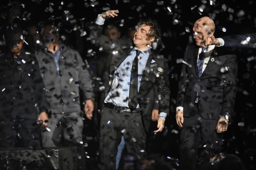 Argentine President Javier Milei, center, and National Deputy Jose Luis Espert celebrate at the end of a promotional event for Milei's new book in Buenos Aires, Argentina, Wednesday, May 22, 2024. (AP Photo/Gustavo Garello)
