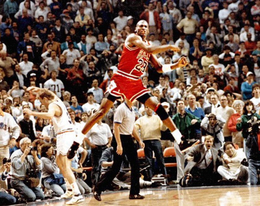 Michael Jordan leaps in the air to celebrate making a playoff series-winning shot for the Bulls over Craig Ehlo of the Cavaliers on May 7, 1989.