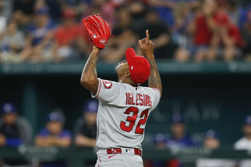 Los Angeles Angels relief pitcher Raisel Iglesias points skyward in celebration of a 5-0 win over the Texas Rangers after a baseball game, Thursday, Aug. 5, 2021, in Arlington, Texas. (AP Photo/Brandon Wade)