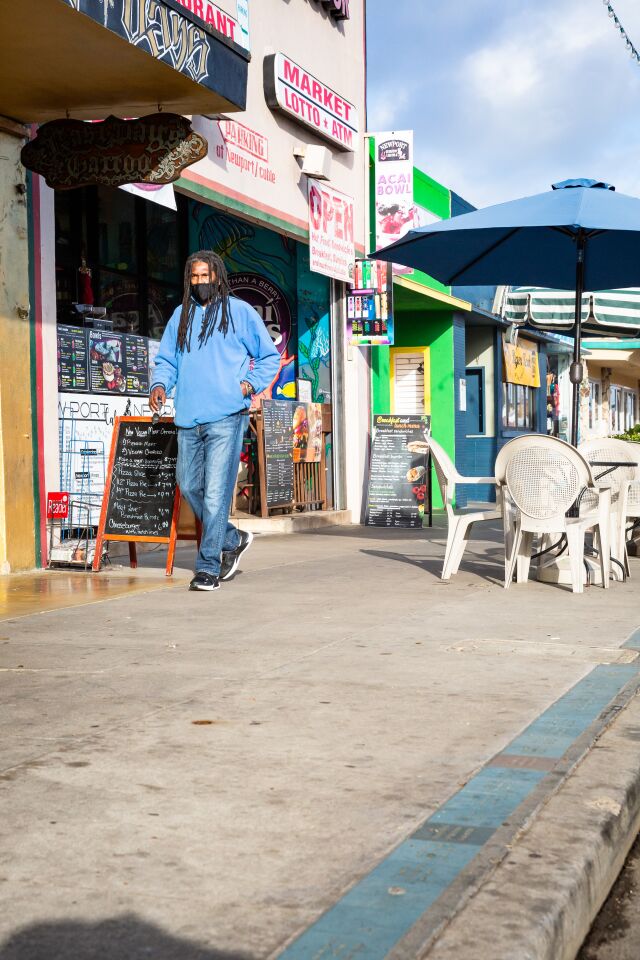 Weldon Pearson walks past the sidewalk tiles in the 4900 block of Newport Avenue in Ocean Beach.