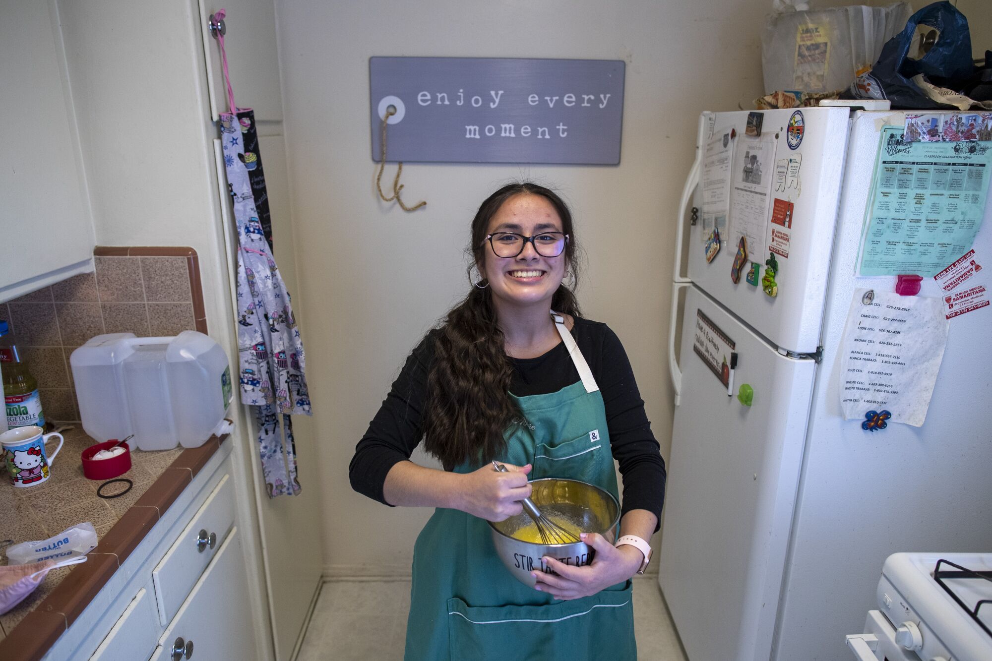 Alhambra High School freshman Abigail Velazquez in the kitchen with an apron and mixing bowl