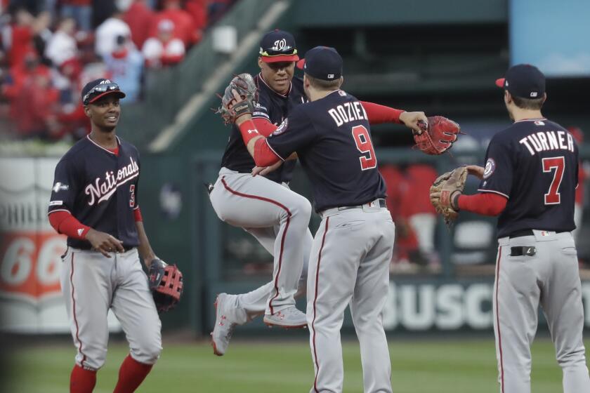 Washington Nationals' Juan Soto and Brian Dozier celebrate after Game 2 of the baseball National League Championship Series against the St. Louis Cardinals Saturday, Oct. 12, 2019, in St. Louis. The Nationals won 3-1 to take a 2-0 lead in the series. (AP Photo/Mark Humphrey)