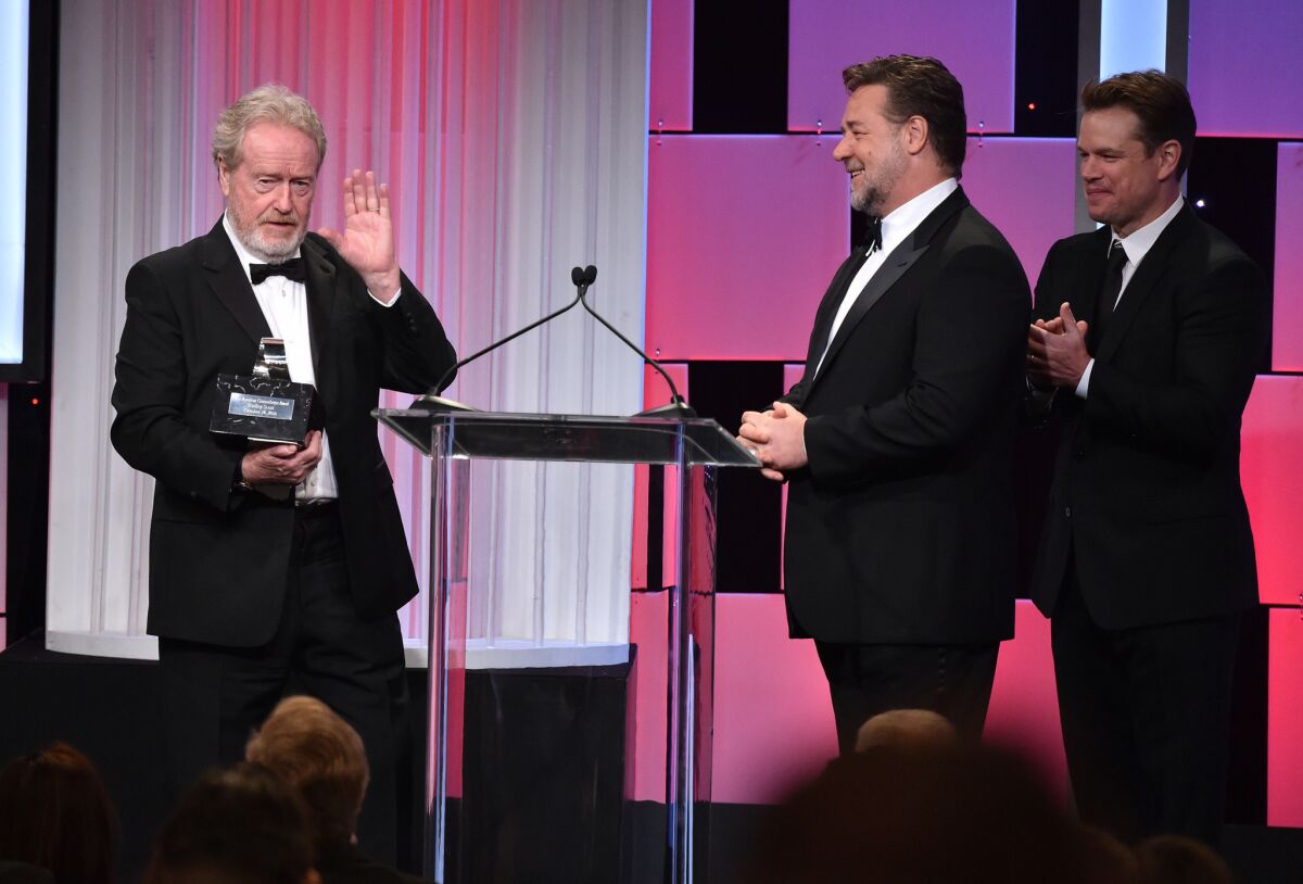 Ridley Scott, left, accepts his award at the 30th American Cinematheque Award at the Beverly Hilton Hotel on Friday with host Russell Crowe, center, and presenter Matt Damon.