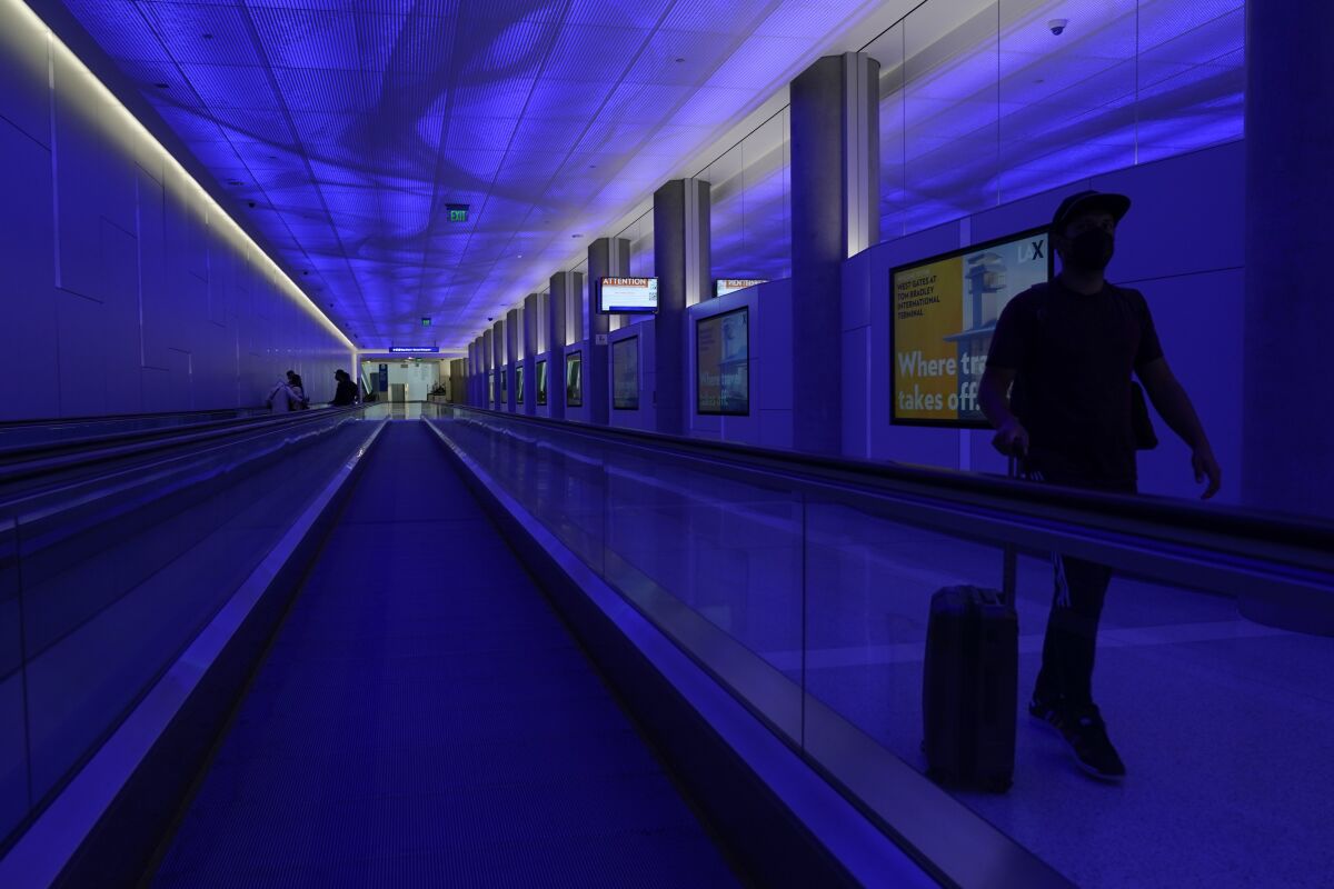 A traveler walks through a tunnel at Los Angeles International Airport 